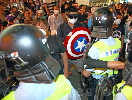 曾假扮法轮功的“香港人优先”张汉贤其中一名手下,连日来混入“雨伞运动”的旺角集会区,打扮成“美国队长”多次带头冲击警方防线。(潘在殊/大纪元)