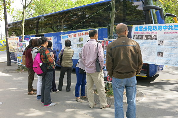 大陆游客认真地观看巴黎退党服务中心的真相展版。(张宇芳/大纪元)