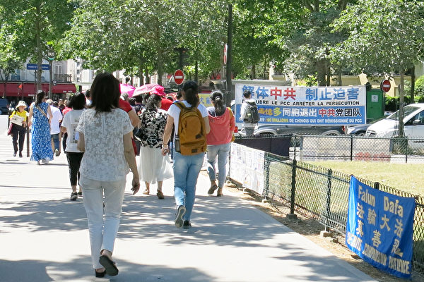 在巴黎艾菲尔铁塔下的真相点,退党服务中心的义工们每天迎来一队接一队的大陆游客。(张宇芳/大纪元)